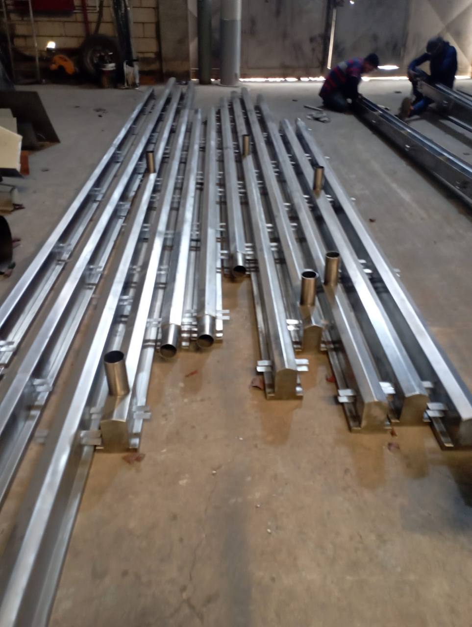 Formed 316 stainless trench sections with welded outlet spigots laid out in the workshop