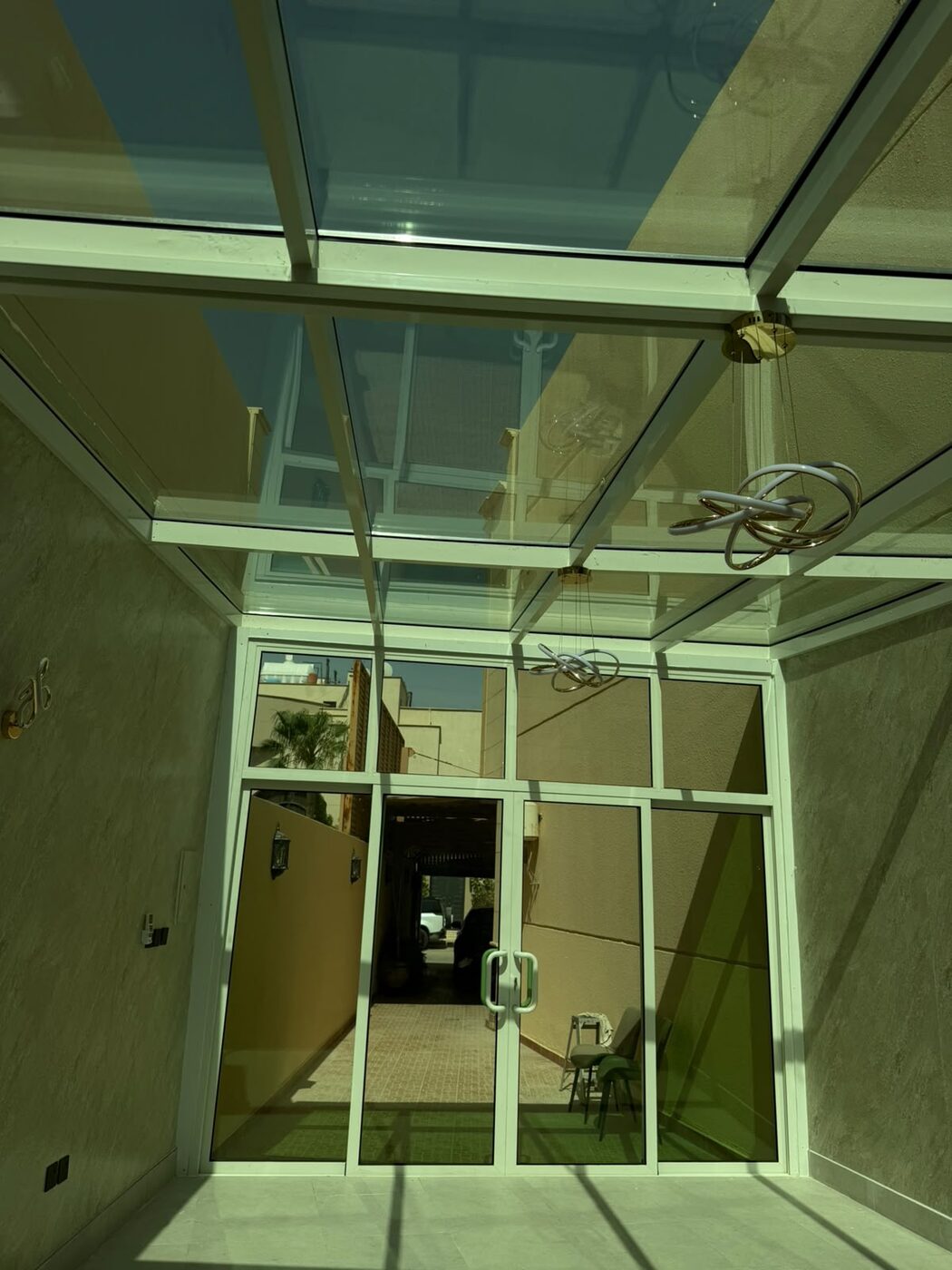 Tinted glass canopy on an aluminum frame over a building entrance in Riyadh