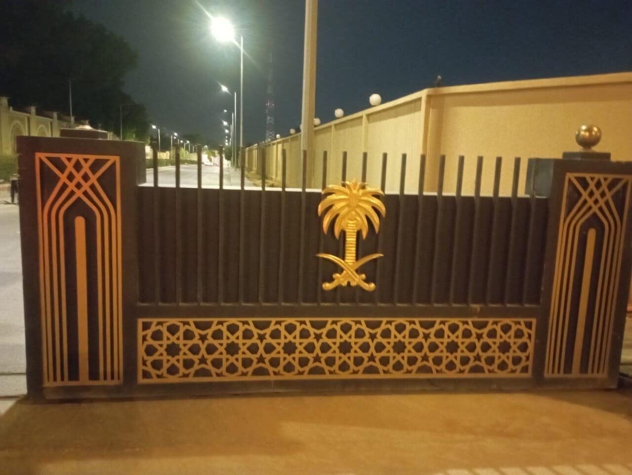 Laser-cut decorative steel fence with an emblem panel, powder-coated and installed in Riyadh