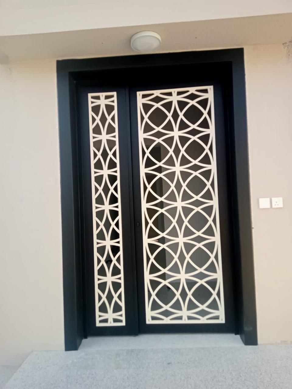 Steel entry door with laser-cut lattice panel and white infill