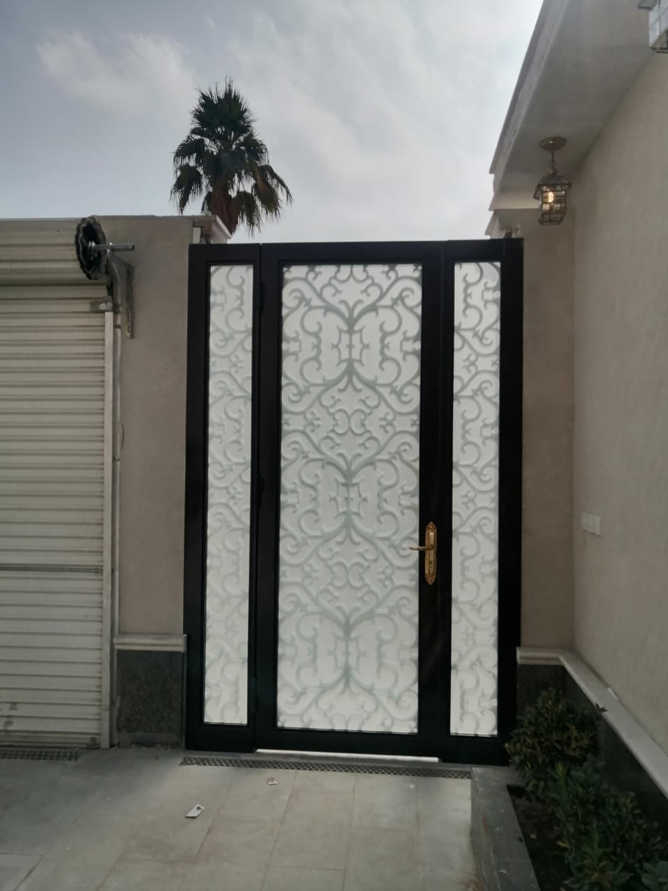 Laser-cut pattern steel gate with brass pull handle, Riyadh