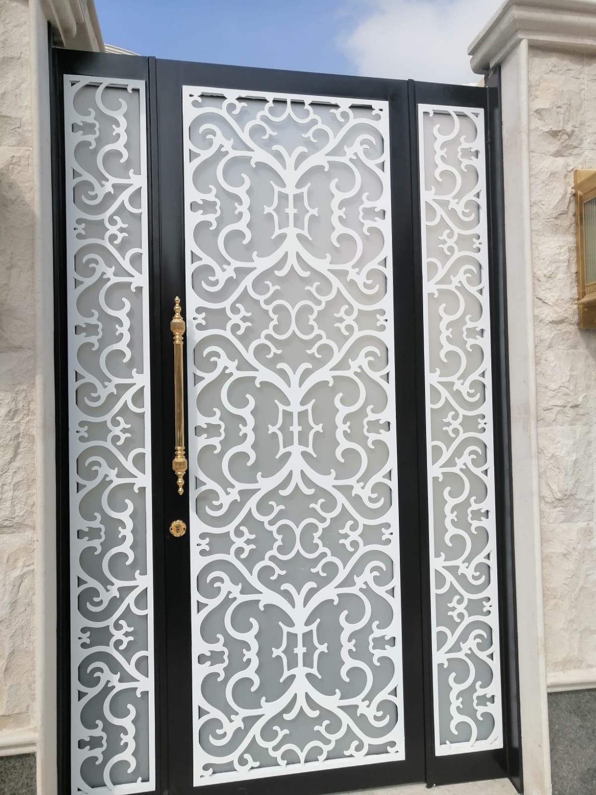 Ornate laser-cut steel swing gate with white powder-coated panels, fabricated by Habibco United in Riyadh