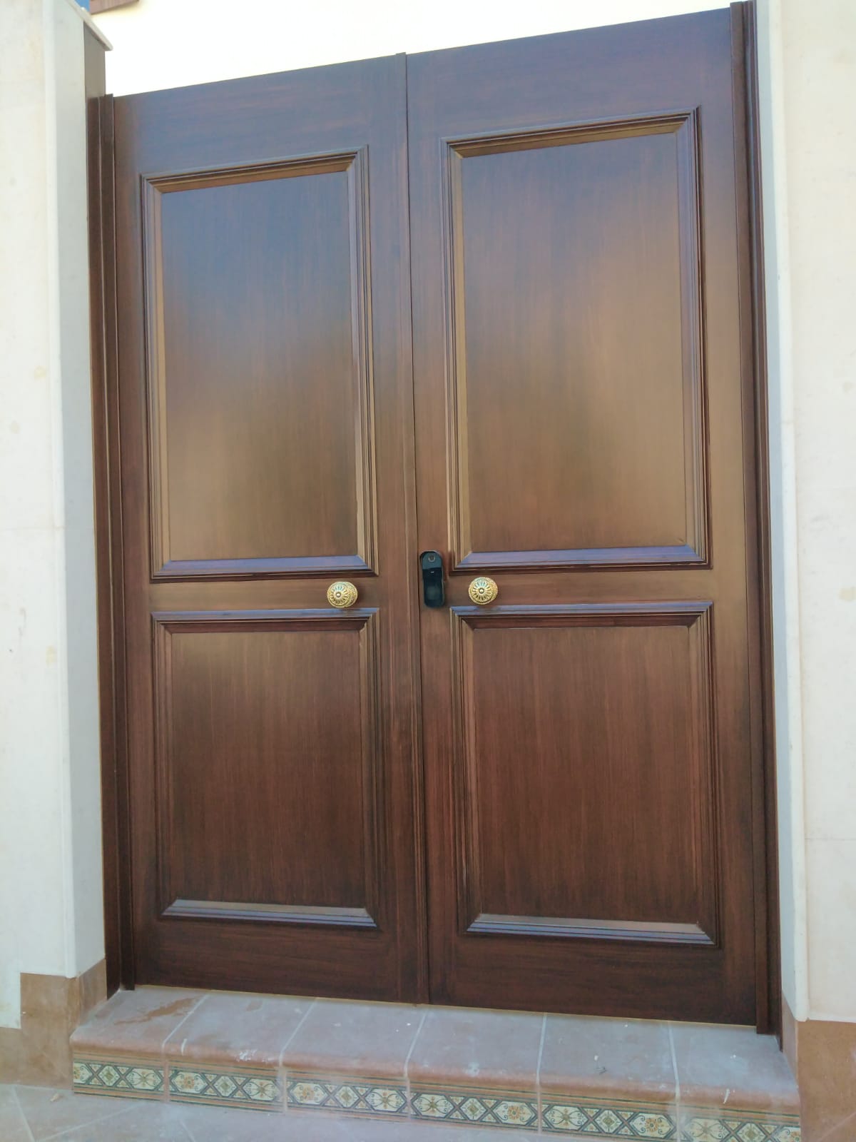 Walnut-finish panelled steel double entry door at a Riyadh villa