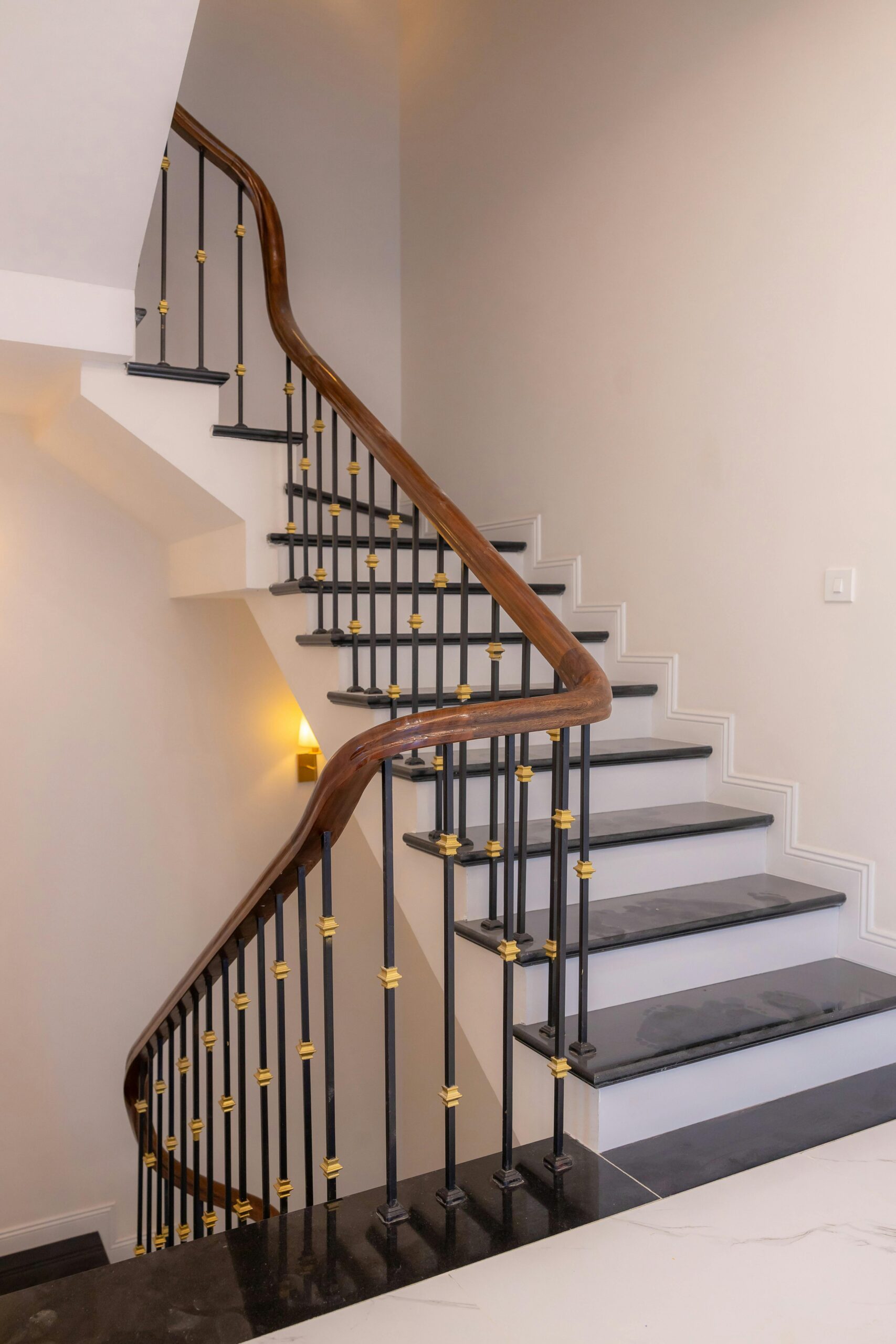 Beautiful spiral staircase with a wooden handrail and sleek design indoors.